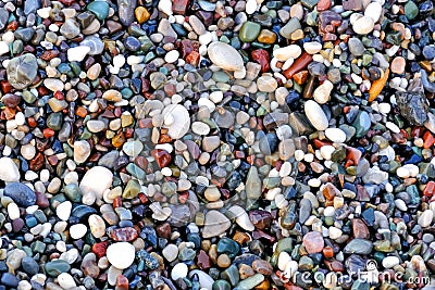 Beautiful texture of wet multicolored pebbles on the sea shore, a unique pattern for design, background, wallpaper Stock Photo